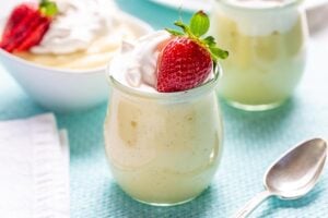 Homemade vanilla pudding in a jar topped with a strawberry