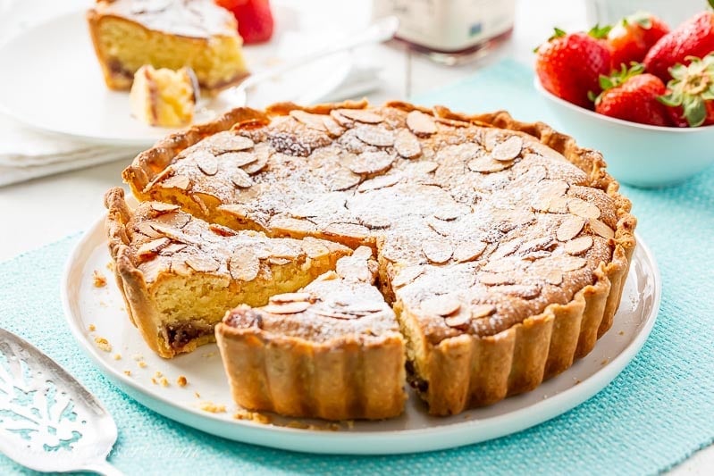 Sliced Bakewell Tart on a platter served with strawberries