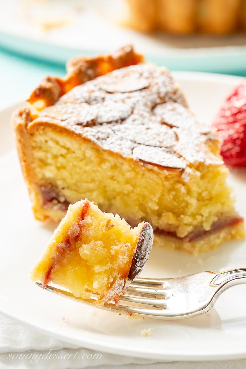 A closeup of a slice of almond tart with a bite on a fork