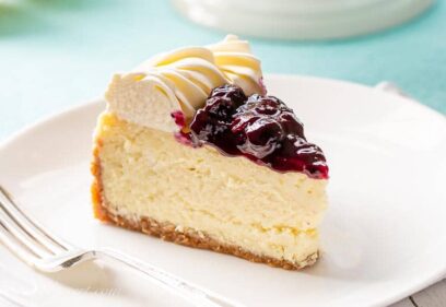 A slice of cheesecake topped with blueberry sauce