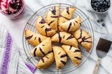 Blueberry Hand Pies in a pile on a cooling rack