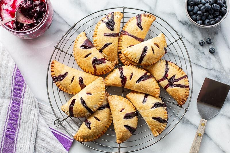 Blueberry Hand Pies in a pile on a cooling rack