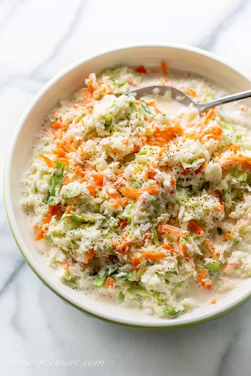An overhead view of a bowl of creamy coleslaw with carrots