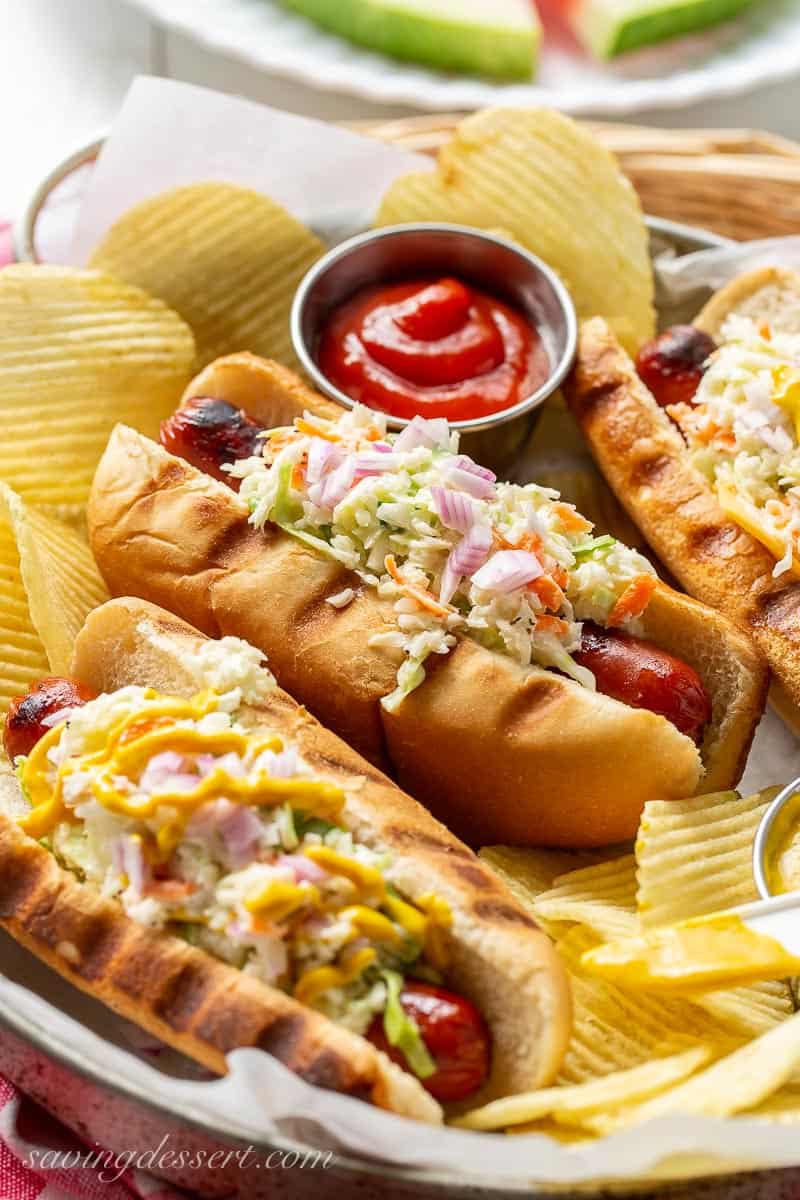 Slaw Dogs topped with creamy coleslaw, mustard and onions served with chips