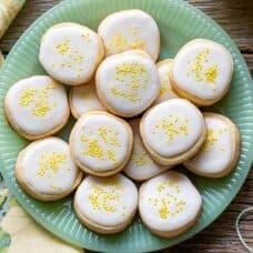 A plate of Lemon Shortbread Cookies iced and covered with yellow sprinkles