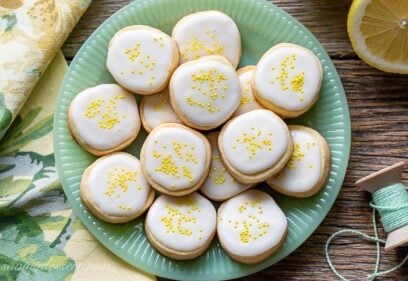 A plate of Lemon Shortbread Cookies iced and covered with yellow sprinkles