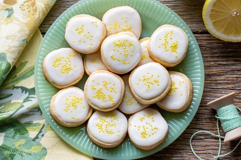 A plate of Lemon Shortbread Cookies iced and covered with yellow sprinkles