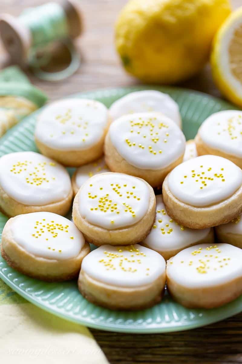 A side view of a plate of lemon cookies with icing and sprinkles