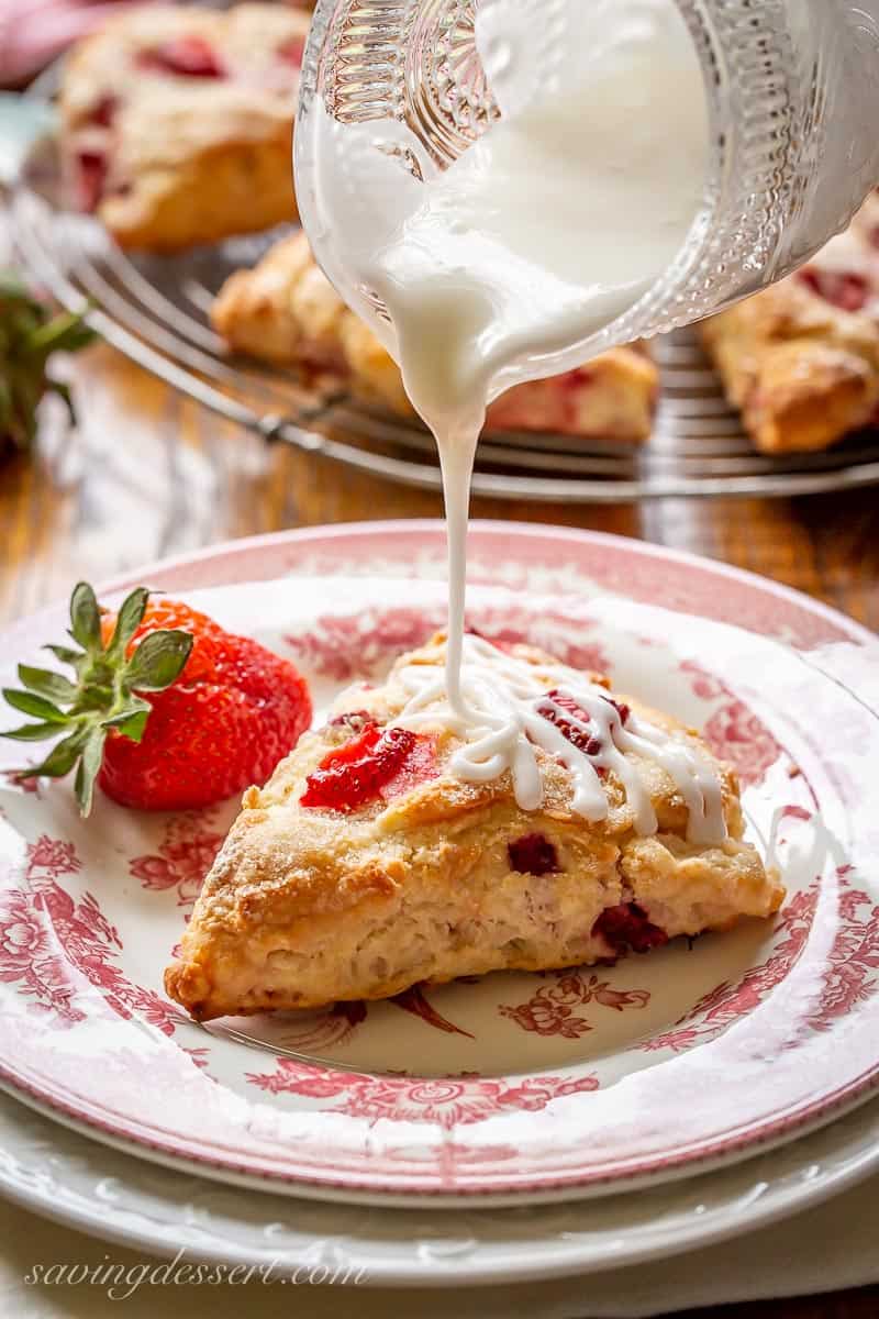 A strawberry scone being drizzled with icing