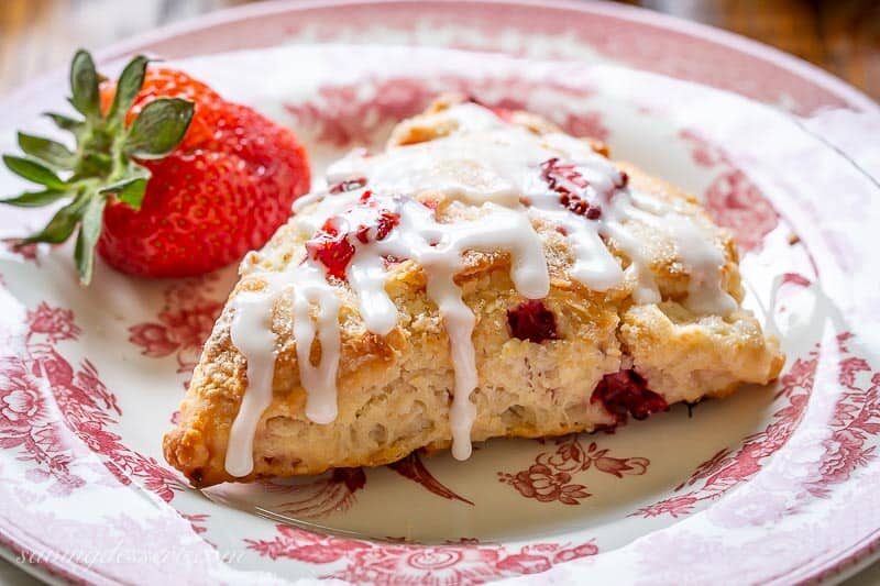 An iced strawberry scone on a plate