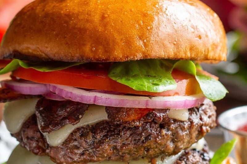 A double stacked grilled burger with french fries on the side.