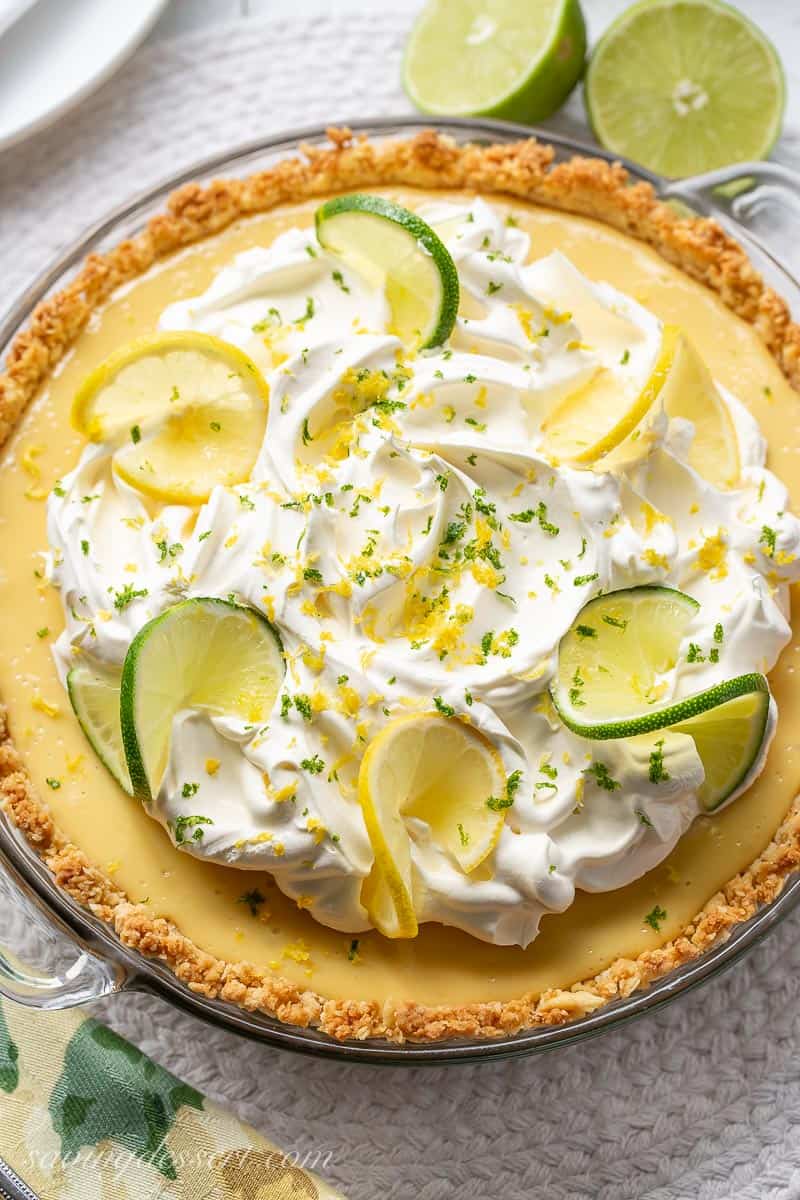 A lemon lime pie with whipped cream in a saltine cracker crust