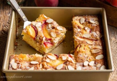 Sliced peach cake in a pan topped with almonds