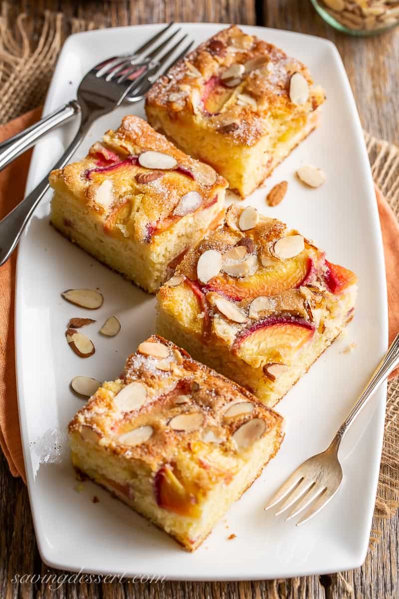 Several pieces of peach cake on a platter with forks
