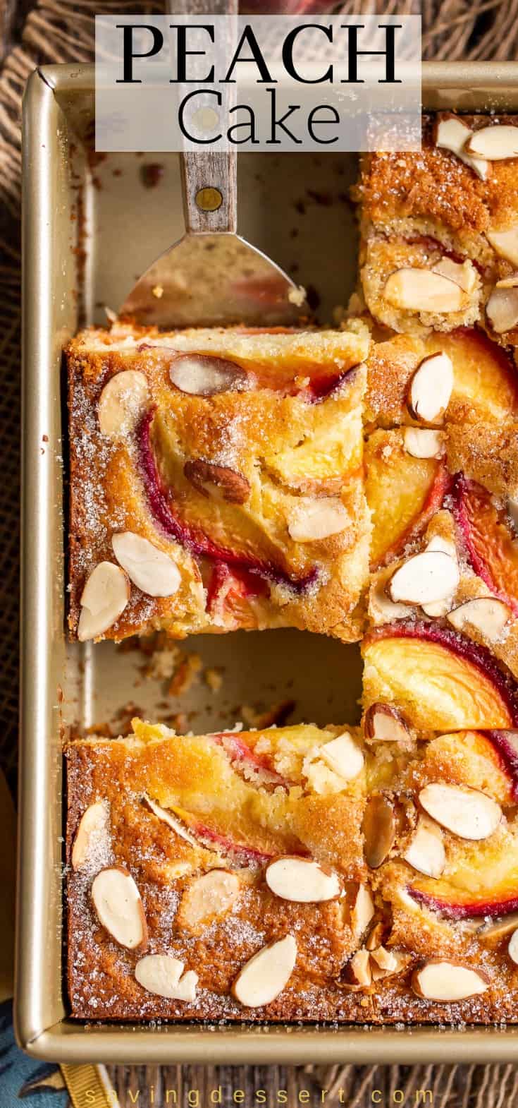 Close up of a slice of peach cake on a spatula in a square pan
