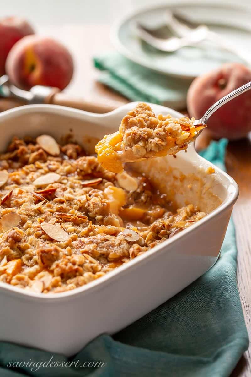 A spoonful of steaming hot peach crisp with oats and almonds