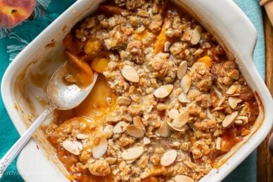 A square baking pan with peach crisp with oats and almonds