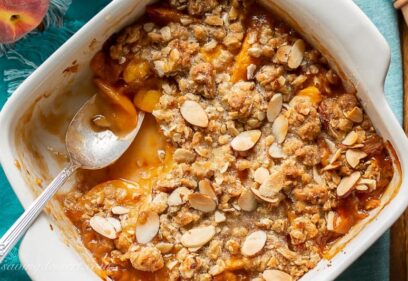 A square baking pan with peach crisp with oats and almonds
