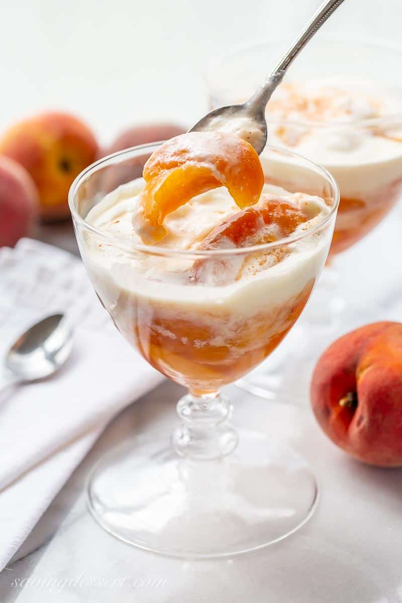 A glass of peaches and cream with a spoon