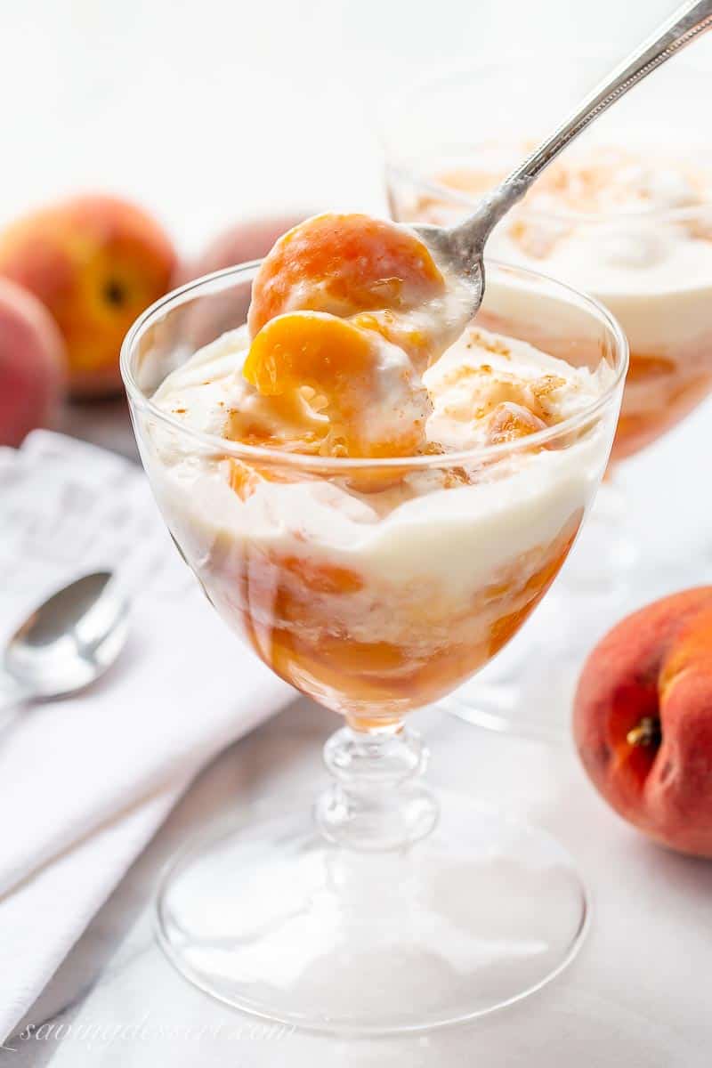 Spoonful of peaches and cream in a stemmed glass