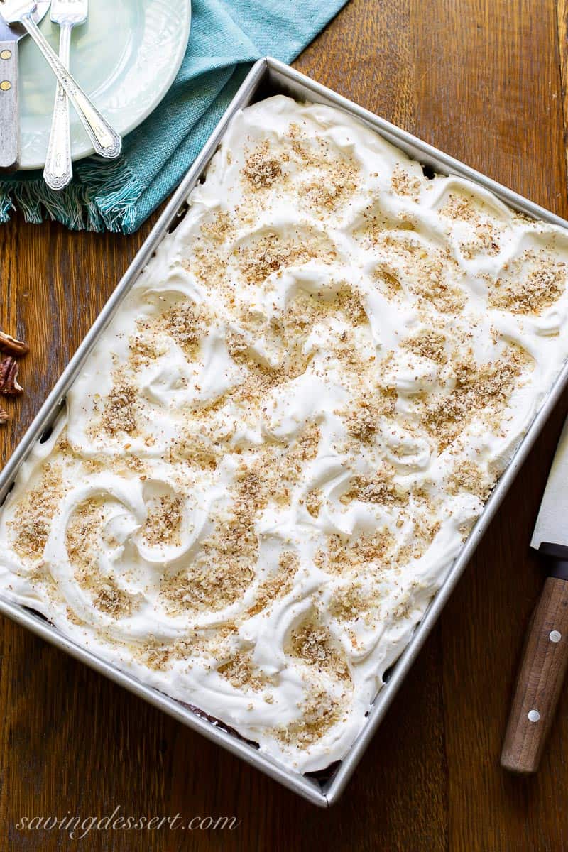 A pan of Chocolate Lasagna topped with whipped cream and grated pecans