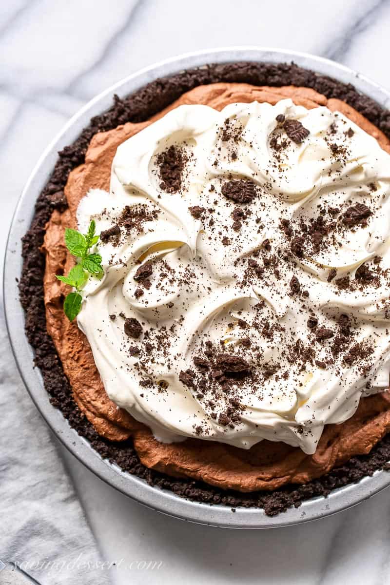 Overhead view of a silky chocolate icebox pie topped with whipped cream and crushed Oreo cookies