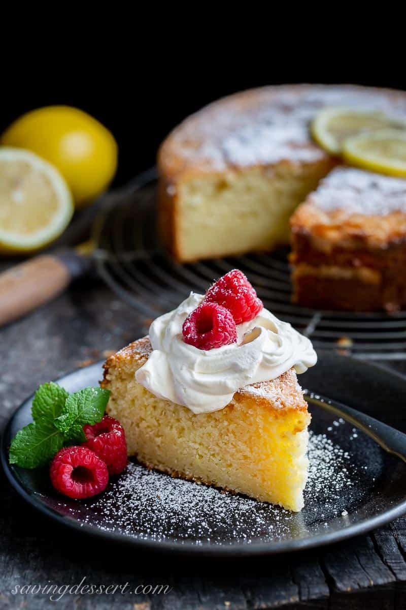 Lemon Ricotta Cake on a plate topped with whipped cream and raspberries