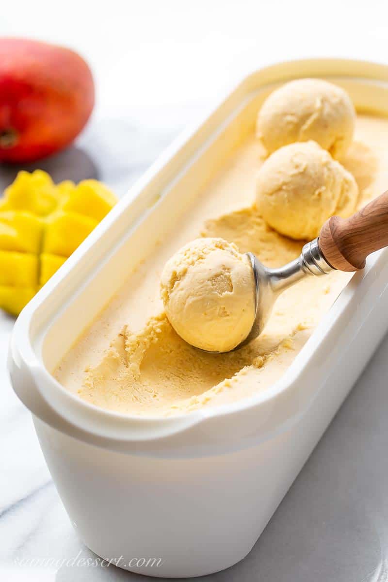 A side view of a freezer container of mango ice cream