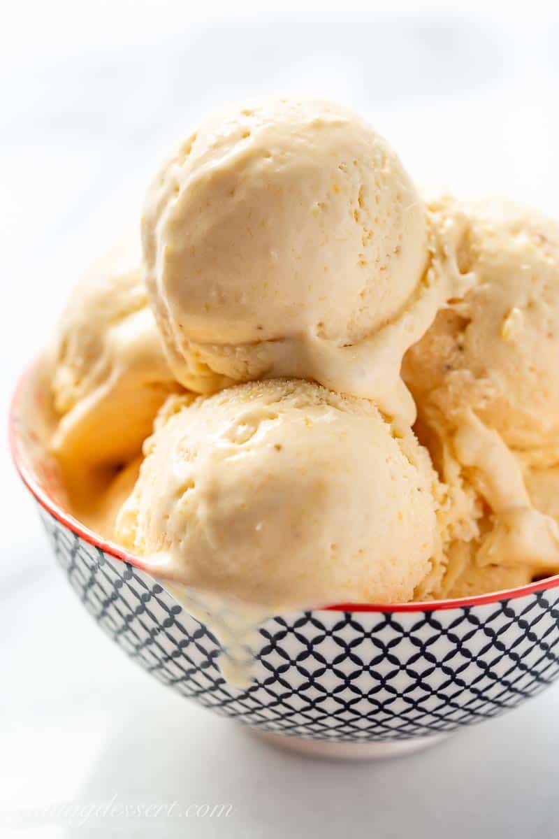 No-churn mango ice cream in a bowl with a drip on the side