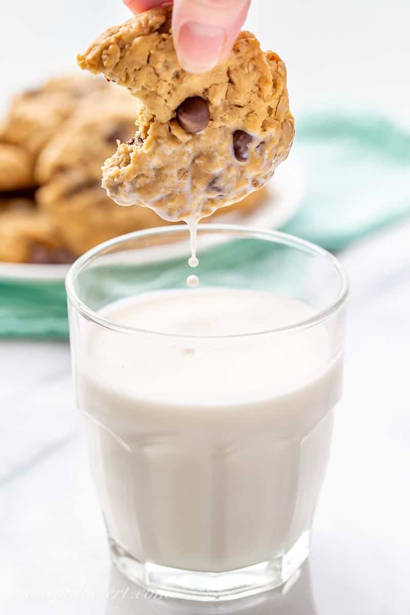 A peanut butter oatmeal cookie dipped in a glass of milk