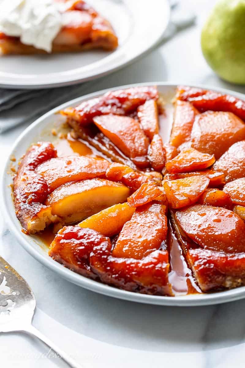 Side view of a platter with a sliced caramel pear tart