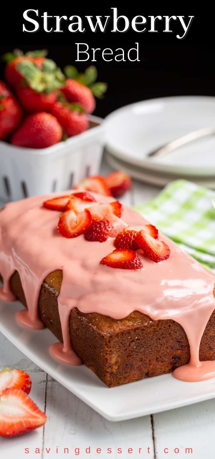 Strawberry bread topped with pink strawberry icing and fresh sliced strawberries