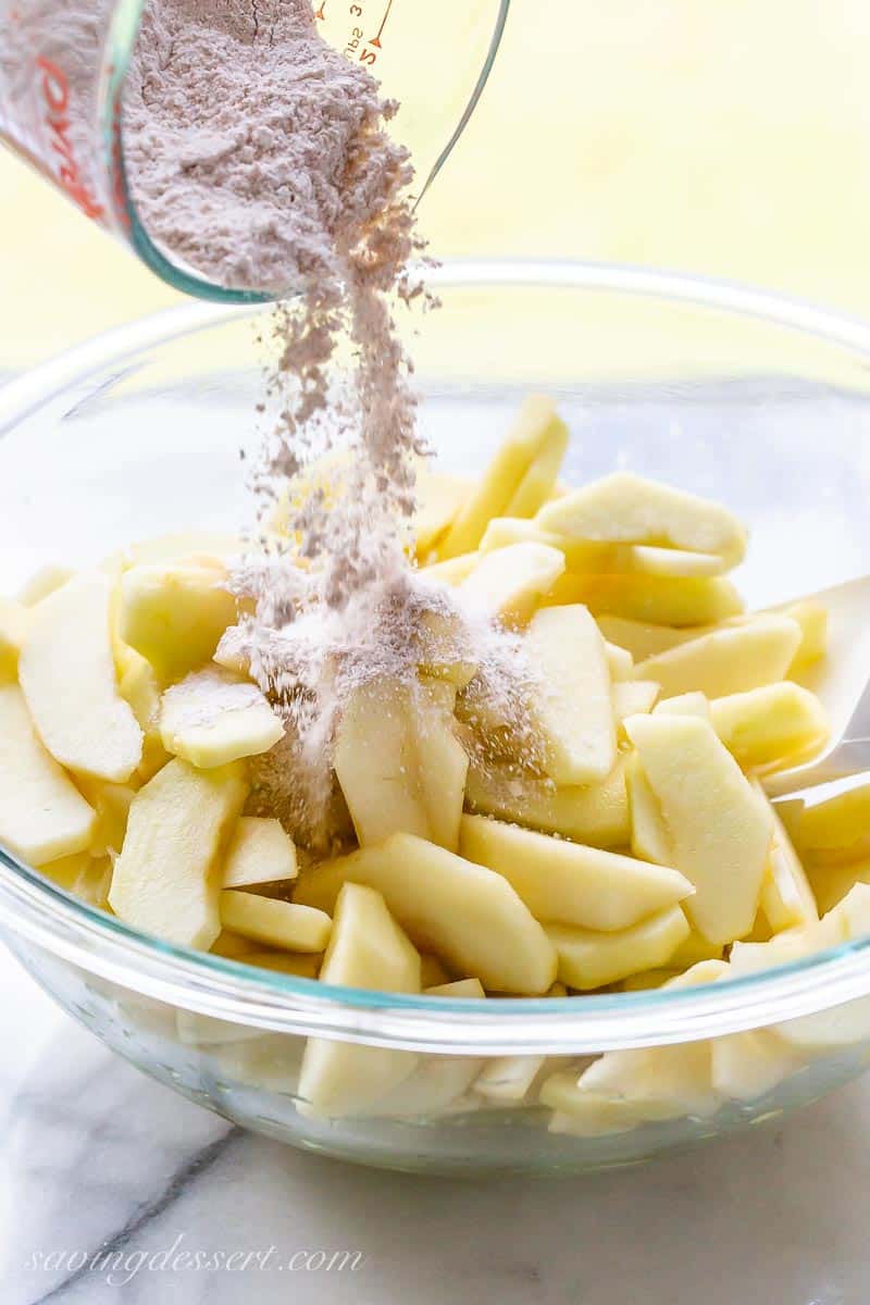 A bowl of apples with a cinnamon sugar mixture poured on top