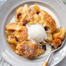 A bowl of juicy apple cobbler topped with melting ice cream