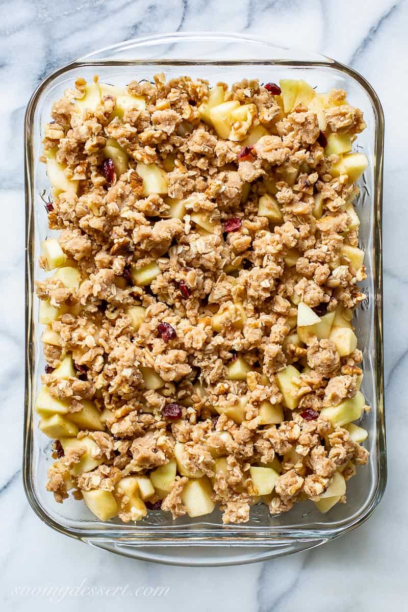 A pan filled with diced apples topped with a oat filled crumbled topped