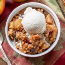 Overhead view of a ramekin filled with apple crisp and ice cream