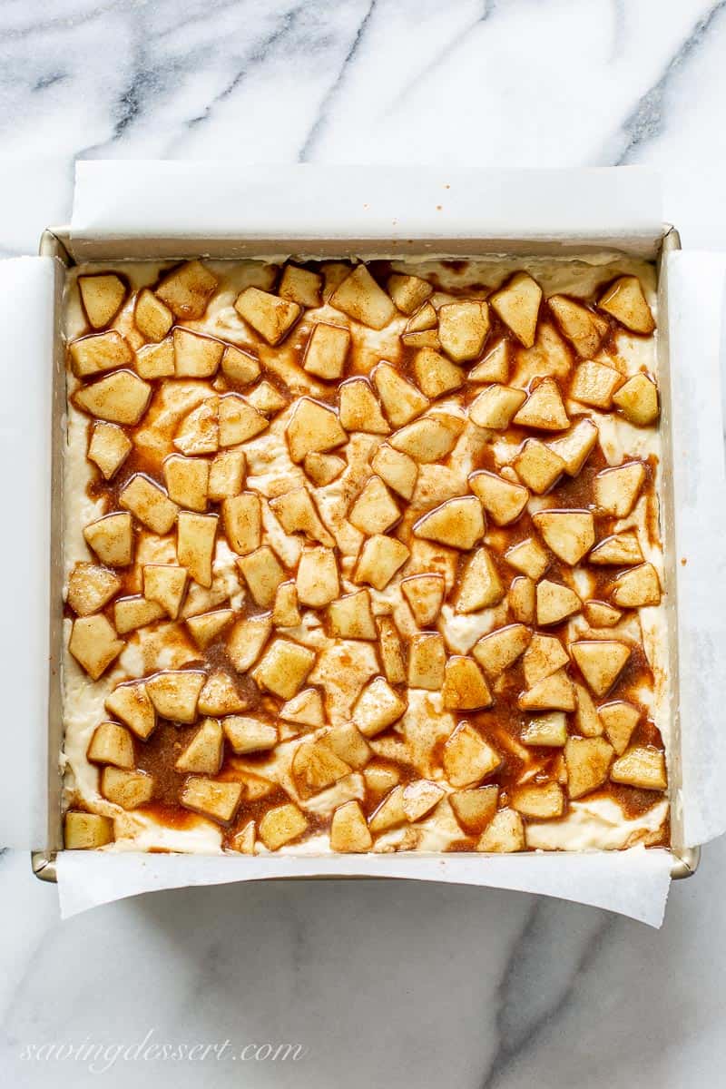 Cinnamon apples over an pan of unbaked cake batter