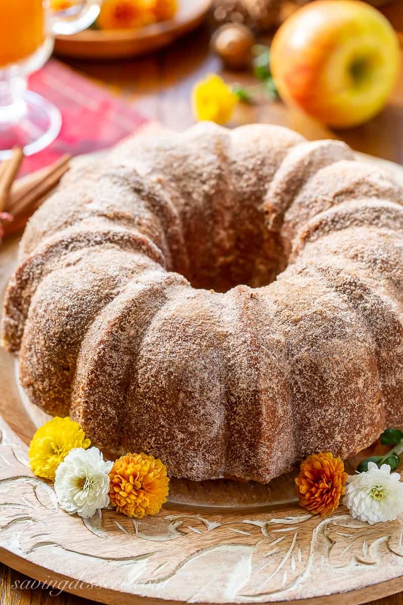 Closeup of an apple cider donut cake served with fall mums and apple cider