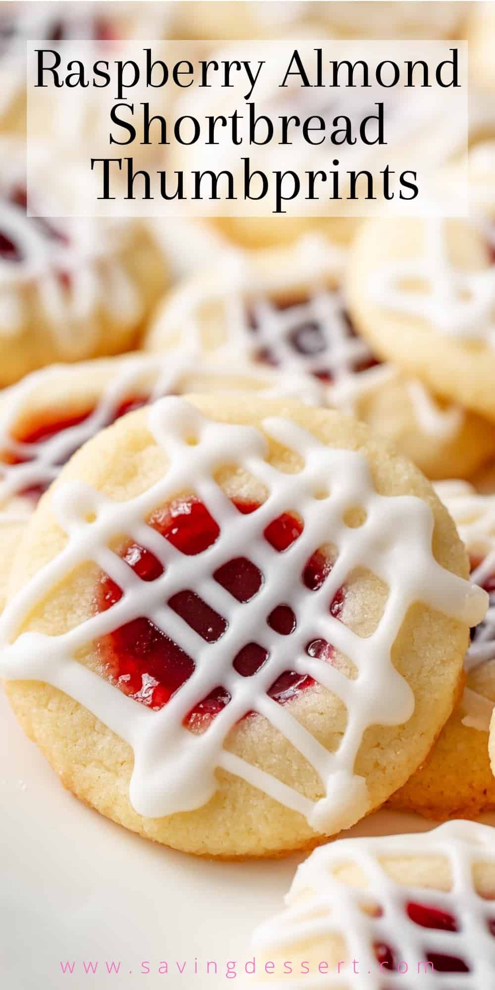 A closeup of a platter of jam filled thumbprint cookies with a drizzle of icing on top
