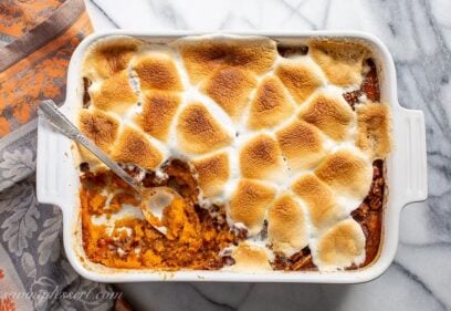 Overhead view of a casserole dish filled with sweet potatoes topped with melted, golden brown toasted marshmallows