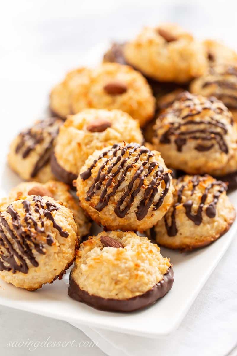Closeup of chocolate drizzled coconut macaroons on a platter