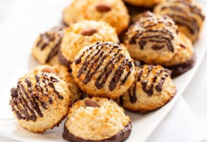 Closeup of a platter of golden brown coconut macaroons dipped and drizzled in chocolate