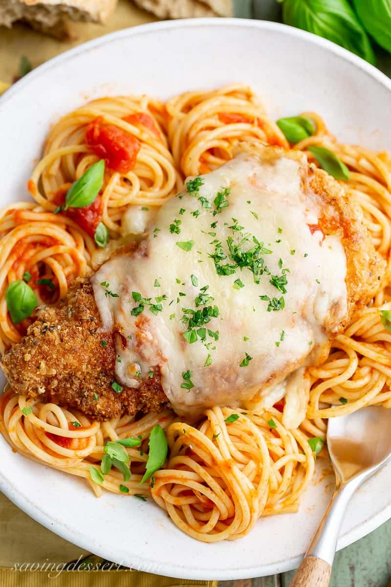 Overhead view of a bowl of spaghetti topped with crispy chicken parmesan