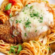 Crispy cheese topped chicken parmesan over spaghetti