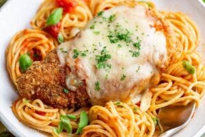 Crispy cheese topped chicken parmesan over spaghetti