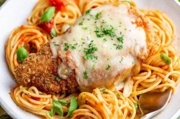 Crispy cheese topped chicken parmesan over spaghetti