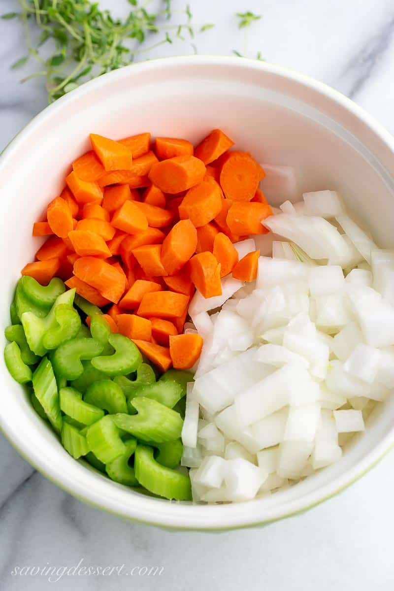 a bowl of chopped celery, carrots and onion