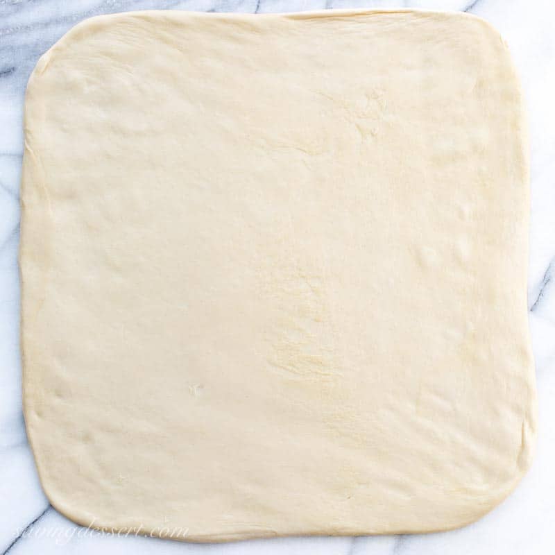A photo of a pizza dough rolled into a square