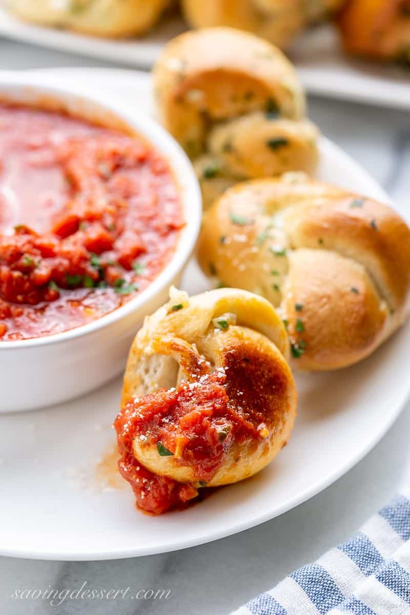 Golden brown bread rolls on a plate with marinara sauce
