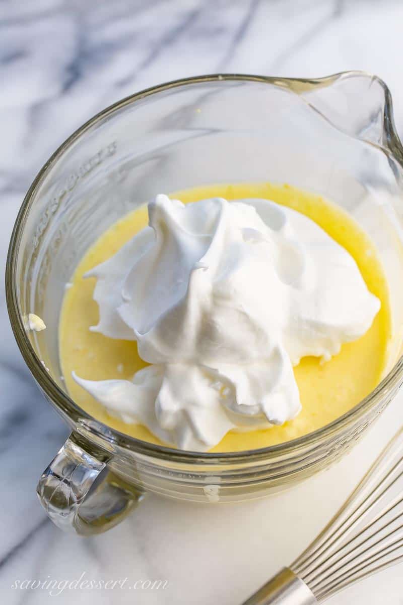 a bowl of lemon batter with whipped egg whites dolloped on top